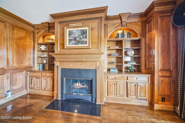 unfurnished living room with dark wood-style flooring, a fireplace, and built in features