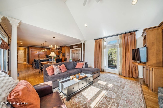 living room featuring high vaulted ceiling, light wood finished floors, recessed lighting, and ornate columns