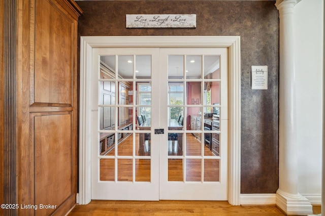 entryway with ornate columns, wood finished floors, and french doors