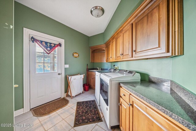 washroom with cabinet space, light tile patterned floors, and washer and dryer