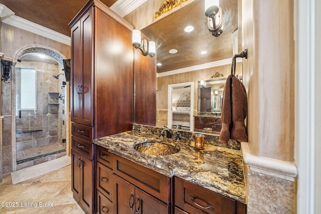 bathroom featuring recessed lighting, ornamental molding, a tile shower, and vanity