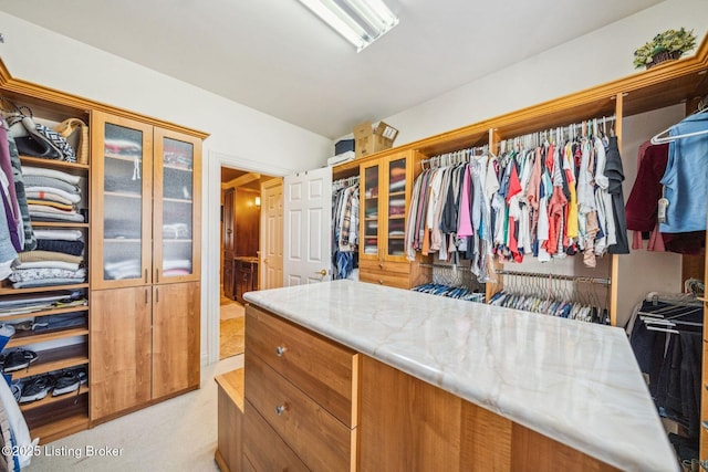 walk in closet featuring lofted ceiling and light colored carpet