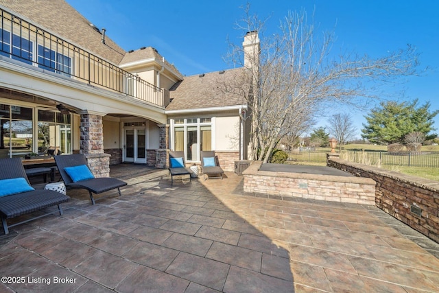 view of patio with french doors, fence, a balcony, and ceiling fan