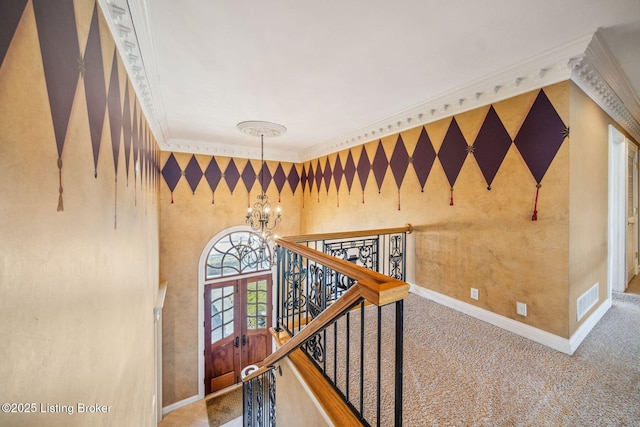 hall featuring a notable chandelier, crown molding, visible vents, baseboards, and wallpapered walls