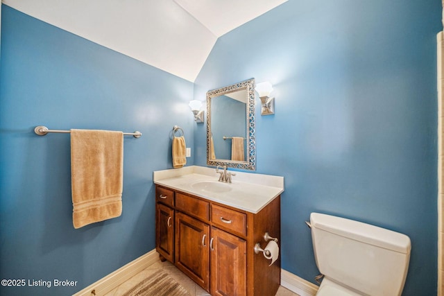 bathroom with lofted ceiling, baseboards, toilet, and vanity