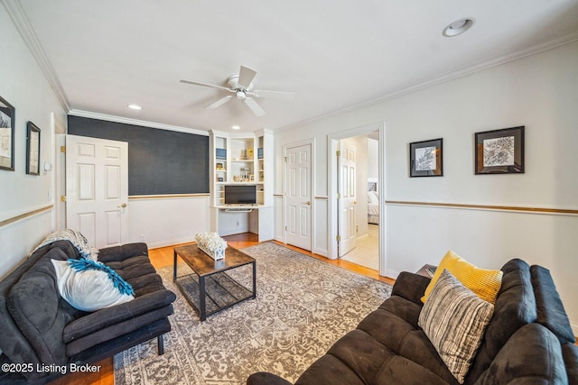 living area with recessed lighting, wood finished floors, a ceiling fan, and crown molding