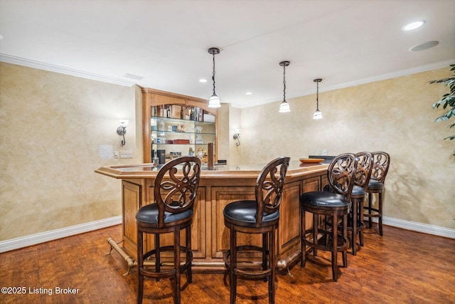 bar featuring baseboards, ornamental molding, wood finished floors, and wet bar