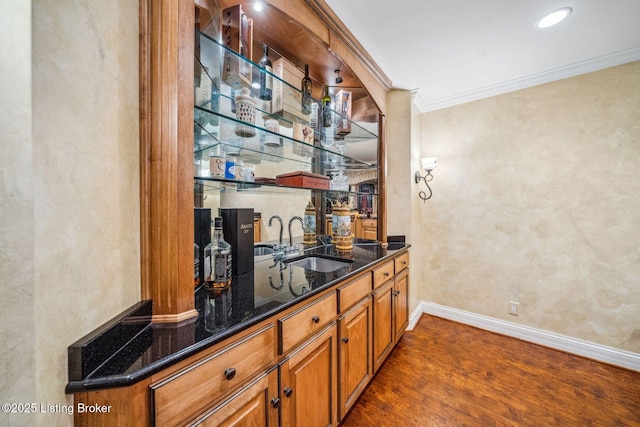 bar featuring a sink, baseboards, ornamental molding, and indoor wet bar