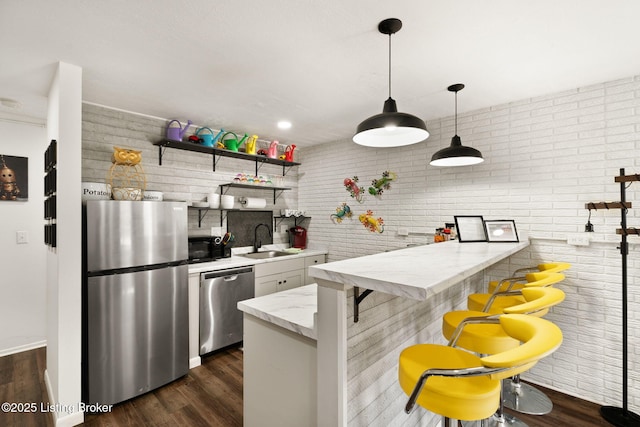 kitchen with open shelves, dark wood-style floors, stainless steel appliances, and a sink