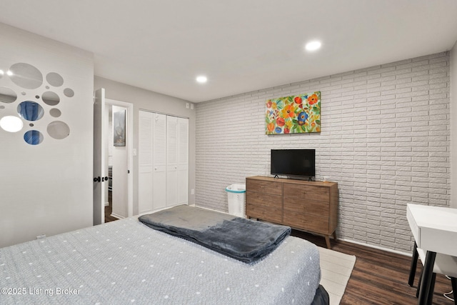 bedroom featuring brick wall, a closet, dark wood-style flooring, and recessed lighting