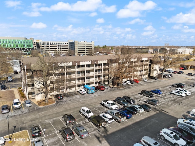 view of building exterior with uncovered parking and a city view