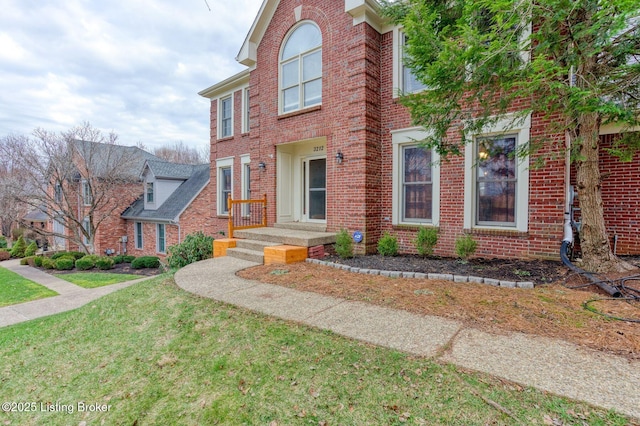 view of front of house with brick siding and a front lawn