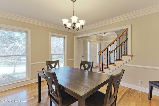 dining room with baseboards, light wood finished floors, an inviting chandelier, and a healthy amount of sunlight