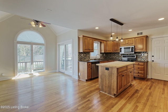 kitchen with light wood-style flooring, stainless steel appliances, wood counters, a sink, and visible vents