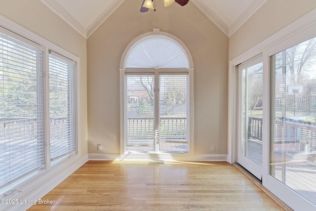 interior space featuring lofted ceiling, ornamental molding, plenty of natural light, and light wood-style floors