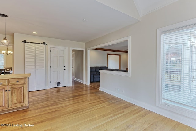 interior space featuring a wealth of natural light, light wood-style flooring, and a barn door