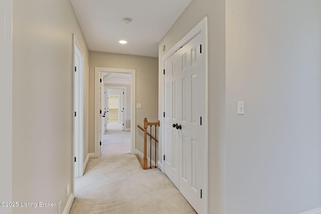 hall featuring light carpet and baseboards