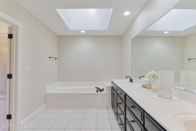 full bath with a skylight, a garden tub, double vanity, a sink, and tile patterned flooring