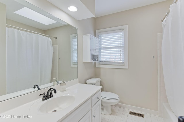 bathroom featuring tile patterned flooring, toilet, a skylight, visible vents, and baseboards