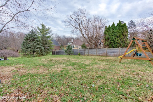 view of yard featuring a playground and fence