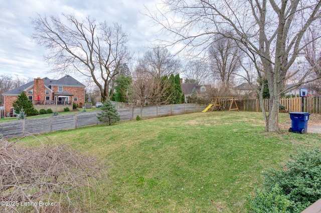 view of yard with a playground and a fenced backyard