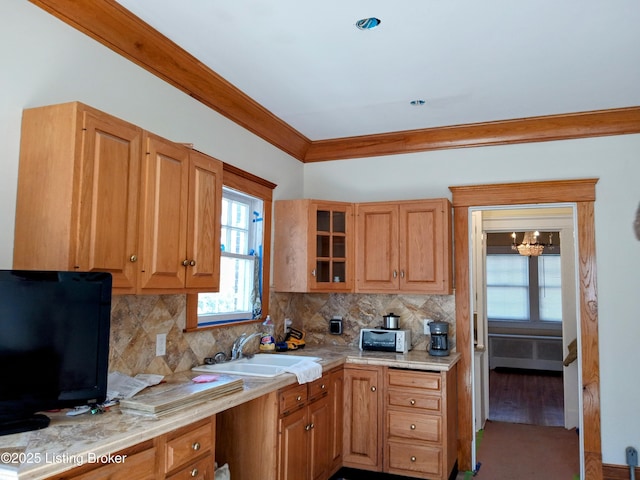 kitchen with tasteful backsplash, light countertops, and a sink