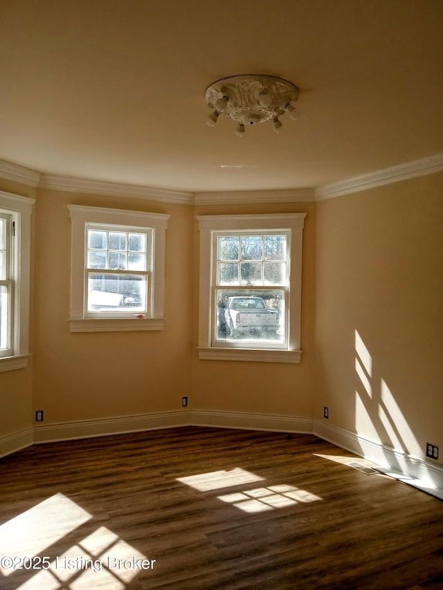 unfurnished room featuring ornamental molding, dark wood finished floors, and baseboards