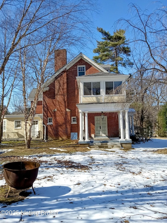 view of front of house featuring a chimney and brick siding