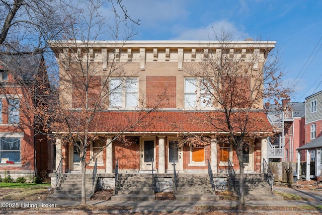 italianate-style house with brick siding and a porch