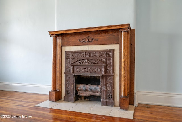 room details with a fireplace, baseboards, and wood finished floors