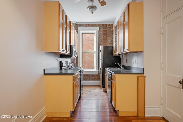 kitchen featuring glass insert cabinets, dark countertops, baseboards, and black appliances