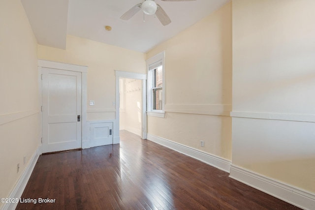 empty room featuring wood finished floors, a ceiling fan, and baseboards