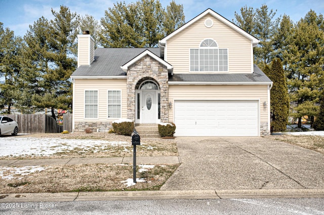 traditional home with driveway, stone siding, a chimney, an attached garage, and fence