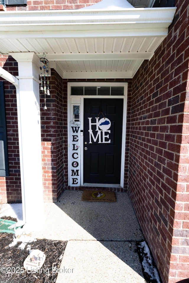 view of exterior entry featuring brick siding