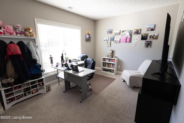 carpeted home office featuring a textured ceiling, visible vents, and baseboards