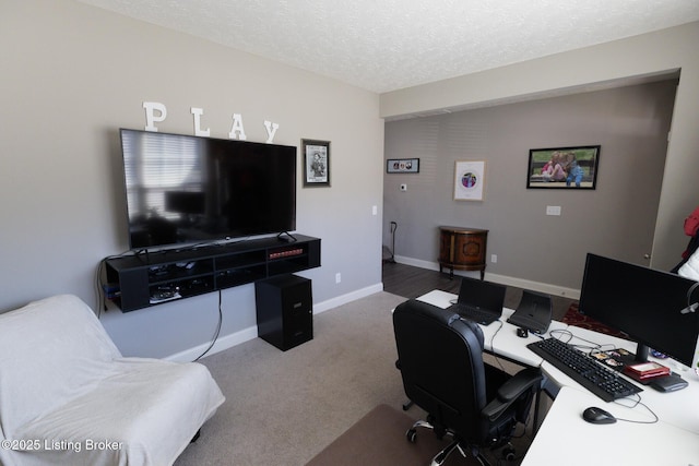 carpeted office with a textured ceiling and baseboards