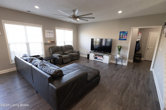 living area featuring dark wood-type flooring, a textured ceiling, and baseboards