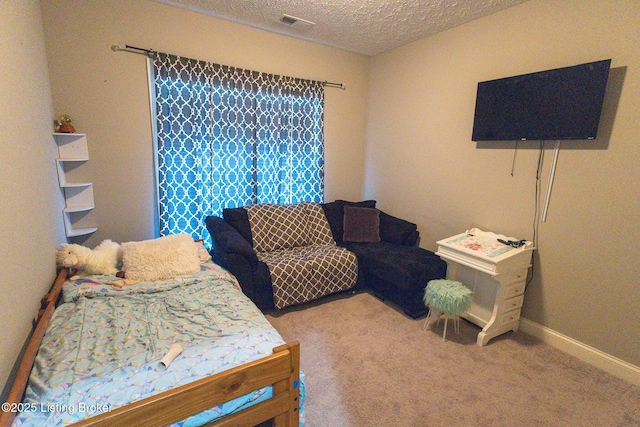 carpeted bedroom with baseboards, visible vents, and a textured ceiling