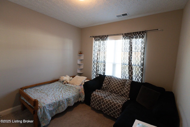 bedroom with a textured ceiling, carpet floors, and visible vents