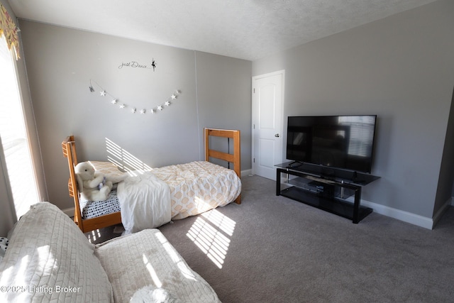 bedroom featuring a textured ceiling, baseboards, and carpet flooring