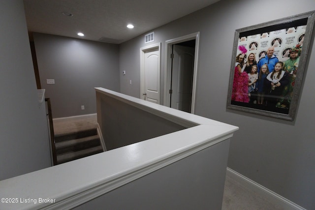 corridor with recessed lighting, baseboards, carpet flooring, and an upstairs landing