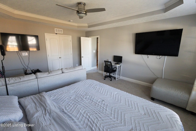 carpeted bedroom featuring a textured ceiling, visible vents, baseboards, ornamental molding, and a raised ceiling