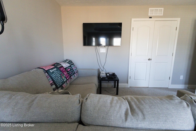 carpeted living room featuring visible vents and baseboards