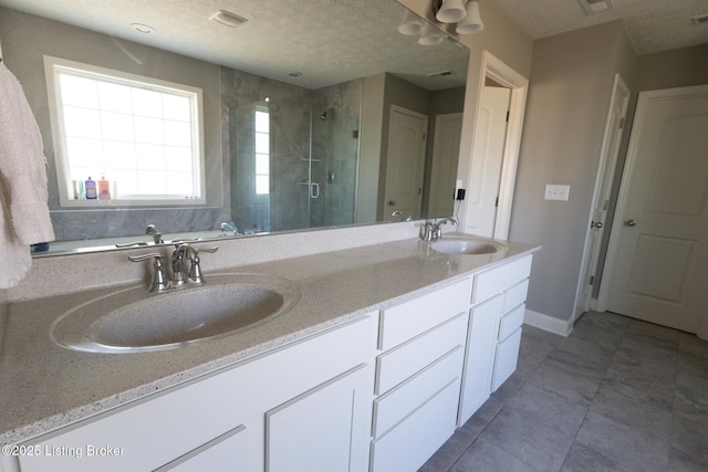 full bath with a stall shower, visible vents, a sink, and double vanity