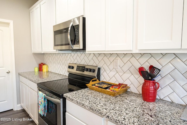 kitchen with decorative backsplash, appliances with stainless steel finishes, light stone counters, dark wood-style flooring, and white cabinetry