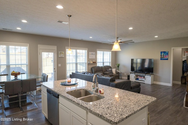 kitchen featuring stainless steel dishwasher, visible vents, dark wood-style flooring, and a sink