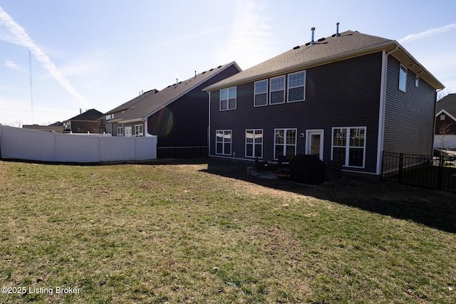 back of house with fence and a yard