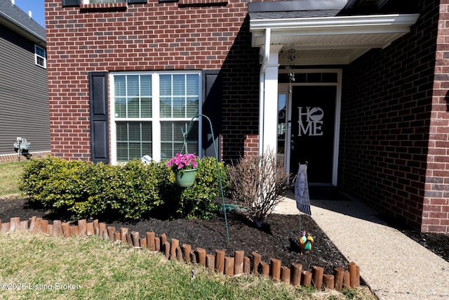 view of exterior entry featuring brick siding