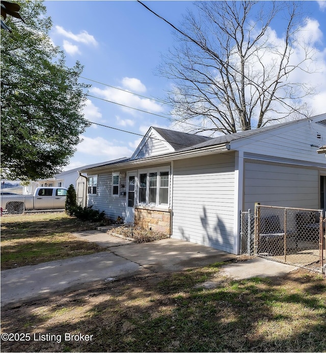 view of front of house featuring stone siding and fence