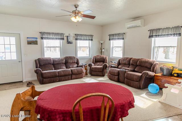 living room with a ceiling fan and a wall unit AC